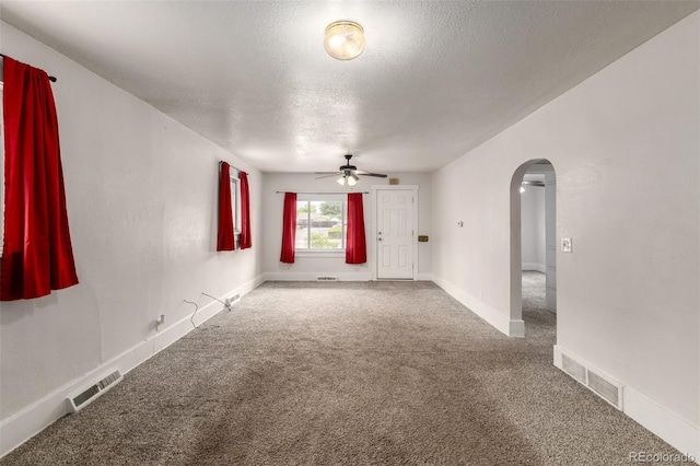 436 S 4th Ave, Brighton, CO 80601 - unfurnished room featuring arched walkways, a ceiling fan, carpet floors, and a textured ceiling