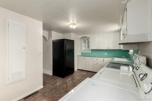 436 S 4th Ave, Brighton, CO 80601 - kitchen with freestanding refrigerator, arched walkways, under cabinet range hood, white cabinetry, and a textured ceiling