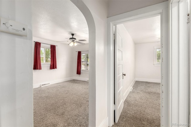 436 S 4th Ave, Brighton, CO 80601 - hallway with carpet floors, arched walkways, and a textured ceiling