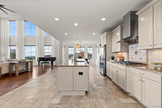 771 Braesheather Pl, Highlands Ranch, CO 80126 - kitchen with wall chimney range hood, appliances with stainless steel finishes, a healthy amount of sunlight, and a sink