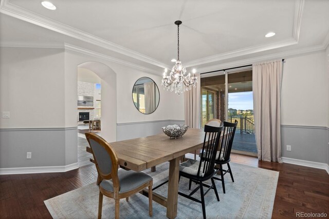 771 Braesheather Pl, Highlands Ranch, CO 80126 - dining area with baseboards, a chandelier, crown molding, wood finished floors, and arched walkways