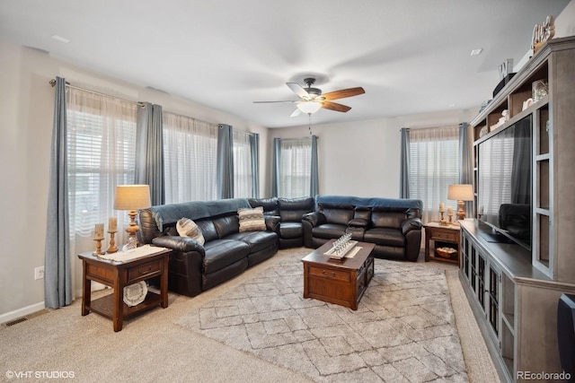 living room with light carpet, a wealth of natural light, and ceiling fan