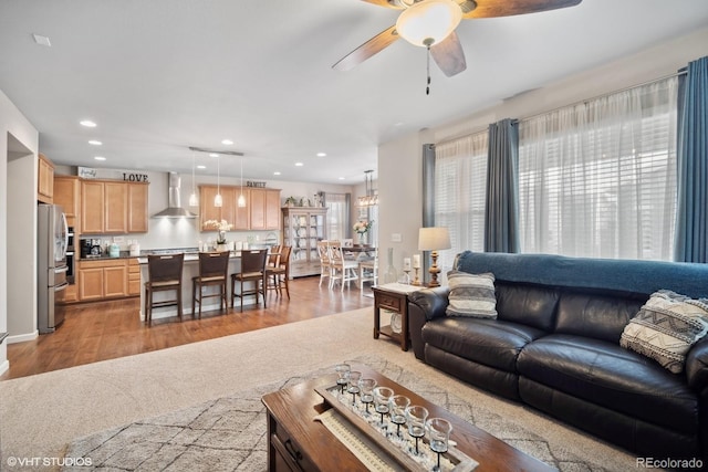 living room with ceiling fan and light hardwood / wood-style flooring