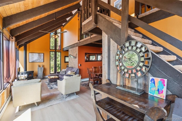 1278 Aspen Dr, Evergreen, CO 80439 - living area with a wood stove, wood finished floors, beamed ceiling, high vaulted ceiling, and stairs