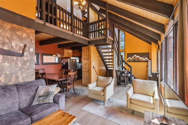 1278 Aspen Dr, Evergreen, CO 80439 - living room with healthy amount of natural light, wood finished floors, stairs, high vaulted ceiling, and wooden ceiling with exposed beams