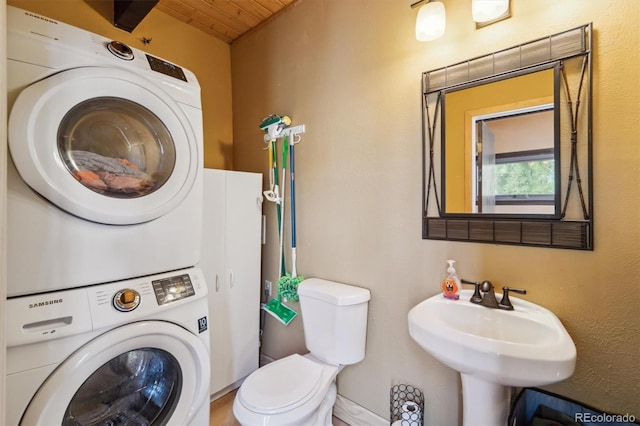1278 Aspen Dr, Evergreen, CO 80439 - bathroom with stacked washing machine and dryer, toilet, and wooden ceiling