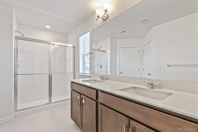 14269 Beebalm Ave, Parker, CO 80134 - full bathroom featuring a stall shower, double vanity, and tile patterned flooring