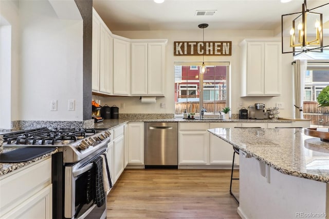 kitchen with light wood-style floors, visible vents, appliances with stainless steel finishes, and white cabinets