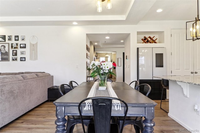 dining area featuring an inviting chandelier, wood finished floors, and recessed lighting