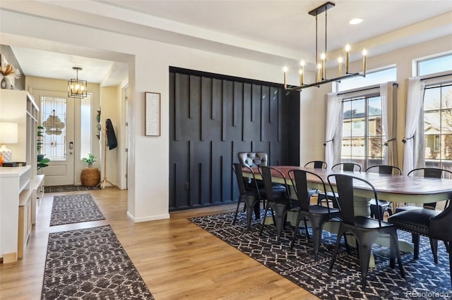 dining area featuring light wood-type flooring, baseboards, a chandelier, and recessed lighting