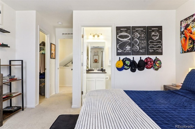 bedroom with carpet flooring, a sink, and ensuite bathroom