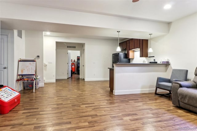 kitchen featuring freestanding refrigerator, open floor plan, visible vents, and wood finished floors