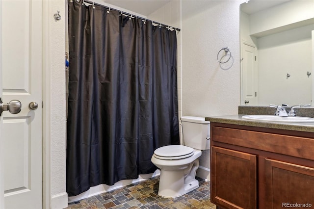 full bathroom with baseboards, a textured wall, toilet, curtained shower, and vanity