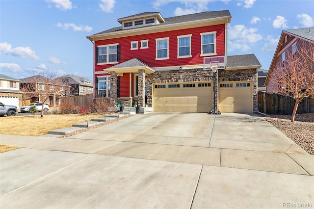 view of front of home featuring an attached garage, stone siding, fence, and concrete driveway