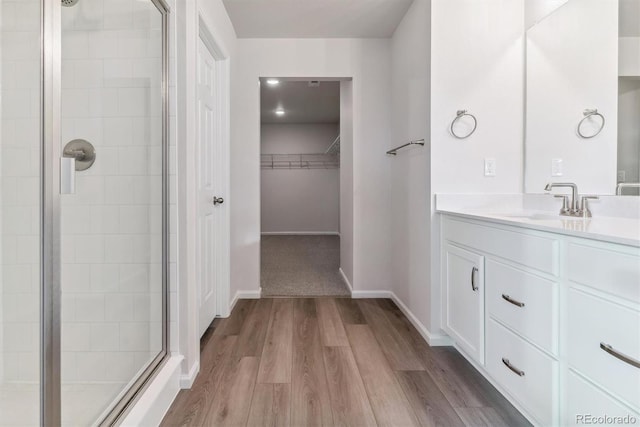 bathroom featuring vanity, hardwood / wood-style flooring, and a shower with door