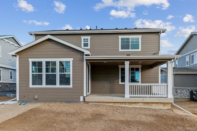 rear view of property featuring covered porch