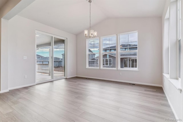 unfurnished dining area featuring vaulted ceiling, an inviting chandelier, and light hardwood / wood-style flooring