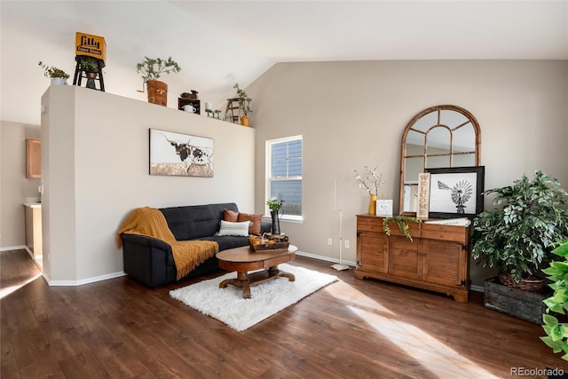 living room featuring baseboards, wood finished floors, and vaulted ceiling