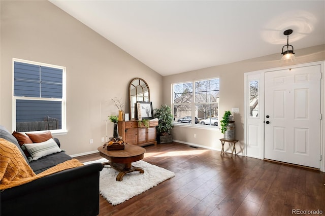 entryway with dark wood finished floors, lofted ceiling, baseboards, and visible vents