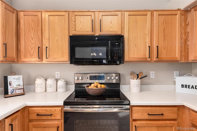 kitchen with light countertops, black microwave, and electric stove