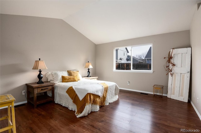 bedroom with visible vents, baseboards, wood finished floors, and vaulted ceiling