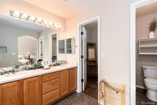 full bathroom featuring tile patterned floors, toilet, ensuite bathroom, a sink, and double vanity