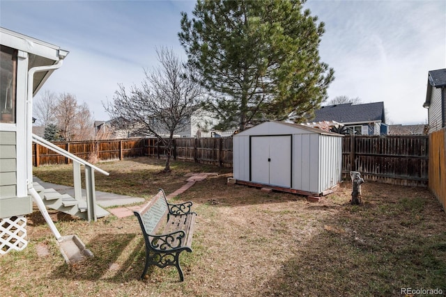 view of yard with an outbuilding, a fenced backyard, and a shed