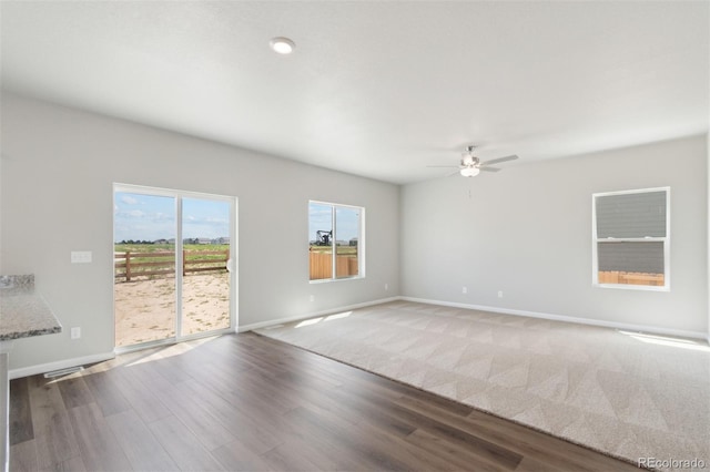 spare room featuring a ceiling fan, baseboards, and wood finished floors