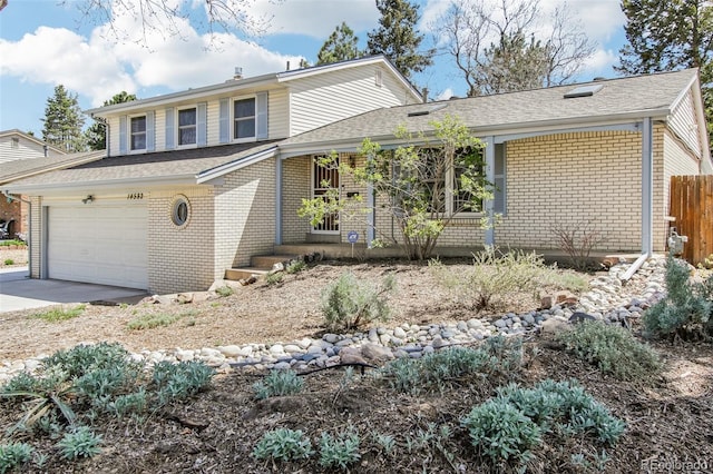 view of front of house with brick siding, a garage, fence, and concrete driveway