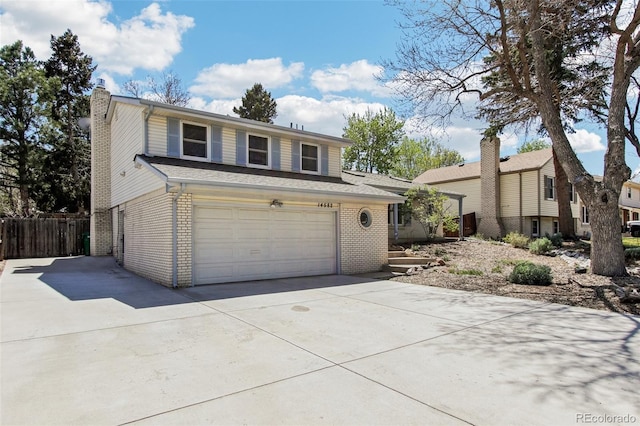 traditional home featuring a garage, fence, a chimney, brick siding, and concrete driveway