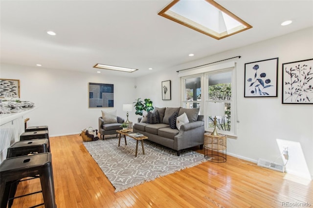 living room featuring recessed lighting, a skylight, visible vents, and hardwood / wood-style flooring