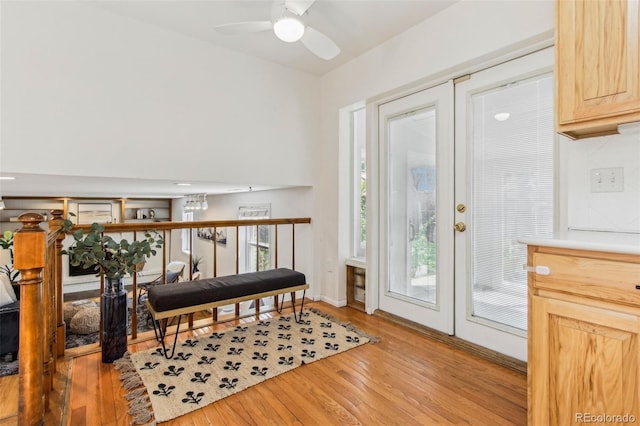 doorway to outside with baseboards, ceiling fan, and light wood-style flooring