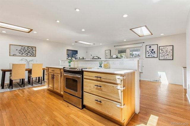 kitchen with recessed lighting, electric stove, light wood finished floors, and light countertops