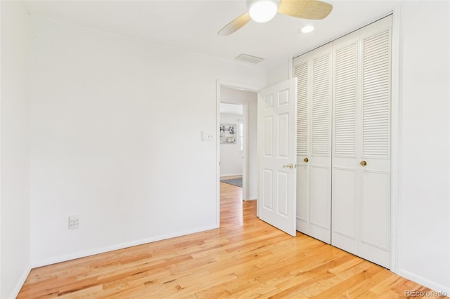 unfurnished bedroom featuring a ceiling fan, baseboards, wood finished floors, and a closet
