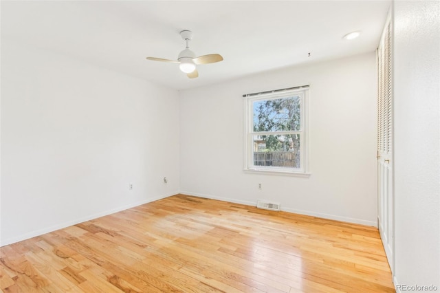 unfurnished room featuring visible vents, a ceiling fan, wood-type flooring, and baseboards