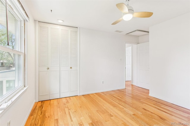 unfurnished bedroom featuring visible vents, a closet, light wood-style floors, baseboards, and a ceiling fan