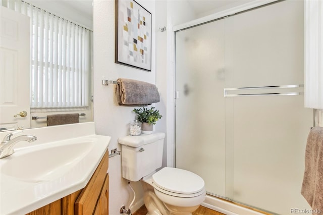 bathroom with vanity, toilet, and a stall shower