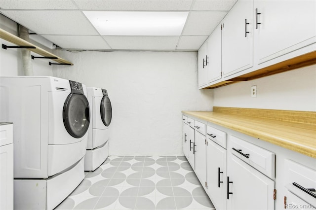 washroom with cabinet space, separate washer and dryer, and light floors