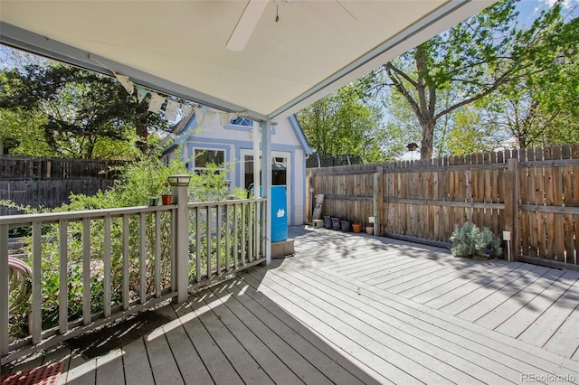 deck with a fenced backyard, a ceiling fan, and an outdoor structure