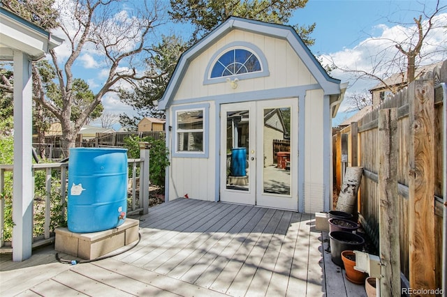 view of outdoor structure featuring a fenced backyard, french doors, and an outbuilding