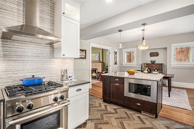 1419 N Adams St, Denver, CO 80206 - kitchen with wall chimney exhaust hood, stainless steel appliances, decorative backsplash, and white cabinetry