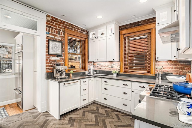 1419 N Adams St, Denver, CO 80206 - kitchen featuring white cabinetry, dark countertops, brick wall, and recessed lighting