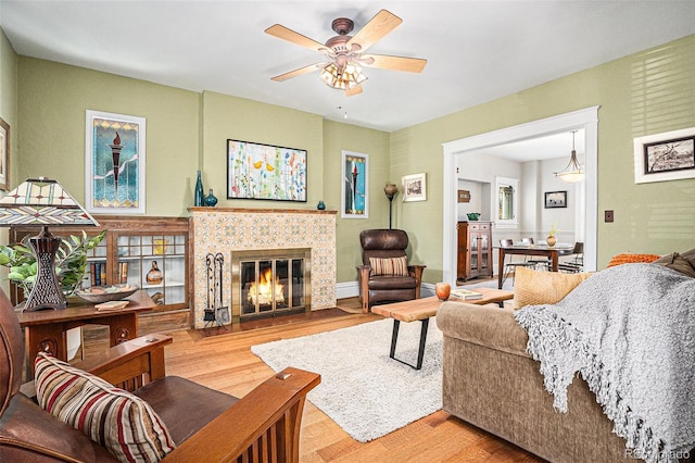 1419 N Adams St, Denver, CO 80206 - living room featuring light wood-type flooring, ceiling fan, and a tiled fireplace