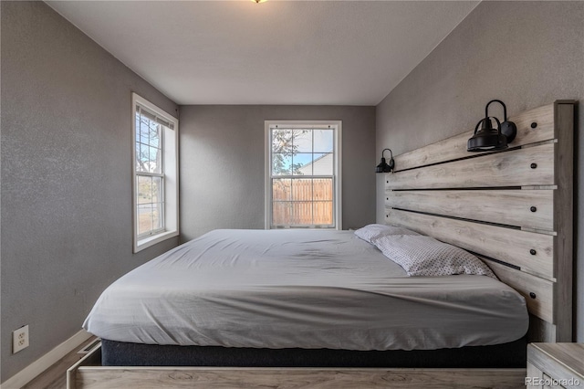 bedroom featuring hardwood / wood-style flooring and multiple windows