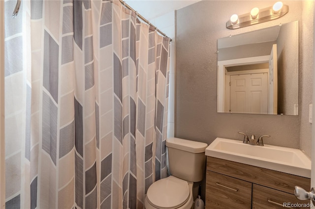 bathroom featuring vanity, toilet, and walk in shower