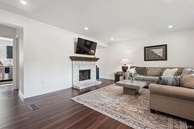 8981 E Amherst Dr Unit E, Denver, CO 80231 - living room featuring dark wood-style flooring, baseboards, a brick fireplace, and recessed lighting