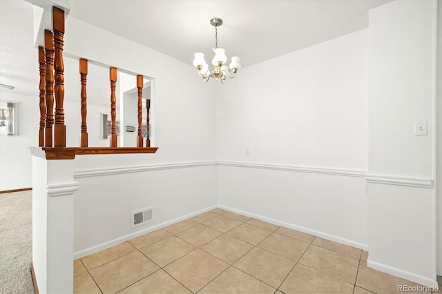 tiled empty room featuring a notable chandelier