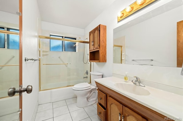 full bathroom featuring vanity, tile patterned floors, shower / bath combination with glass door, and toilet