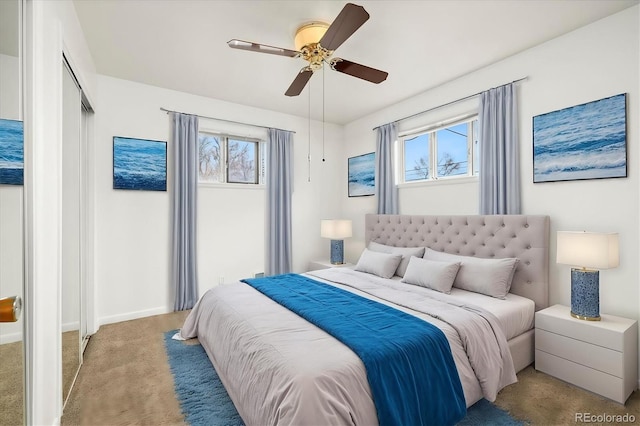 carpeted bedroom featuring multiple windows, a closet, and ceiling fan