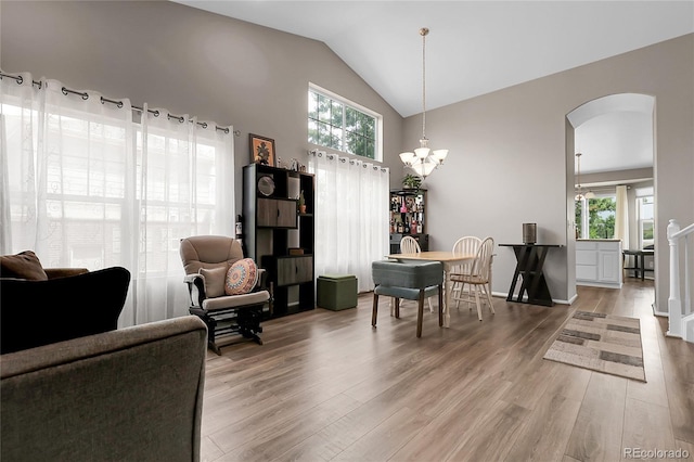 4912 S Fultondale Way, Aurora, CO 80016 - dining space featuring arched walkways, healthy amount of natural light, wood finished floors, a chandelier, and high vaulted ceiling